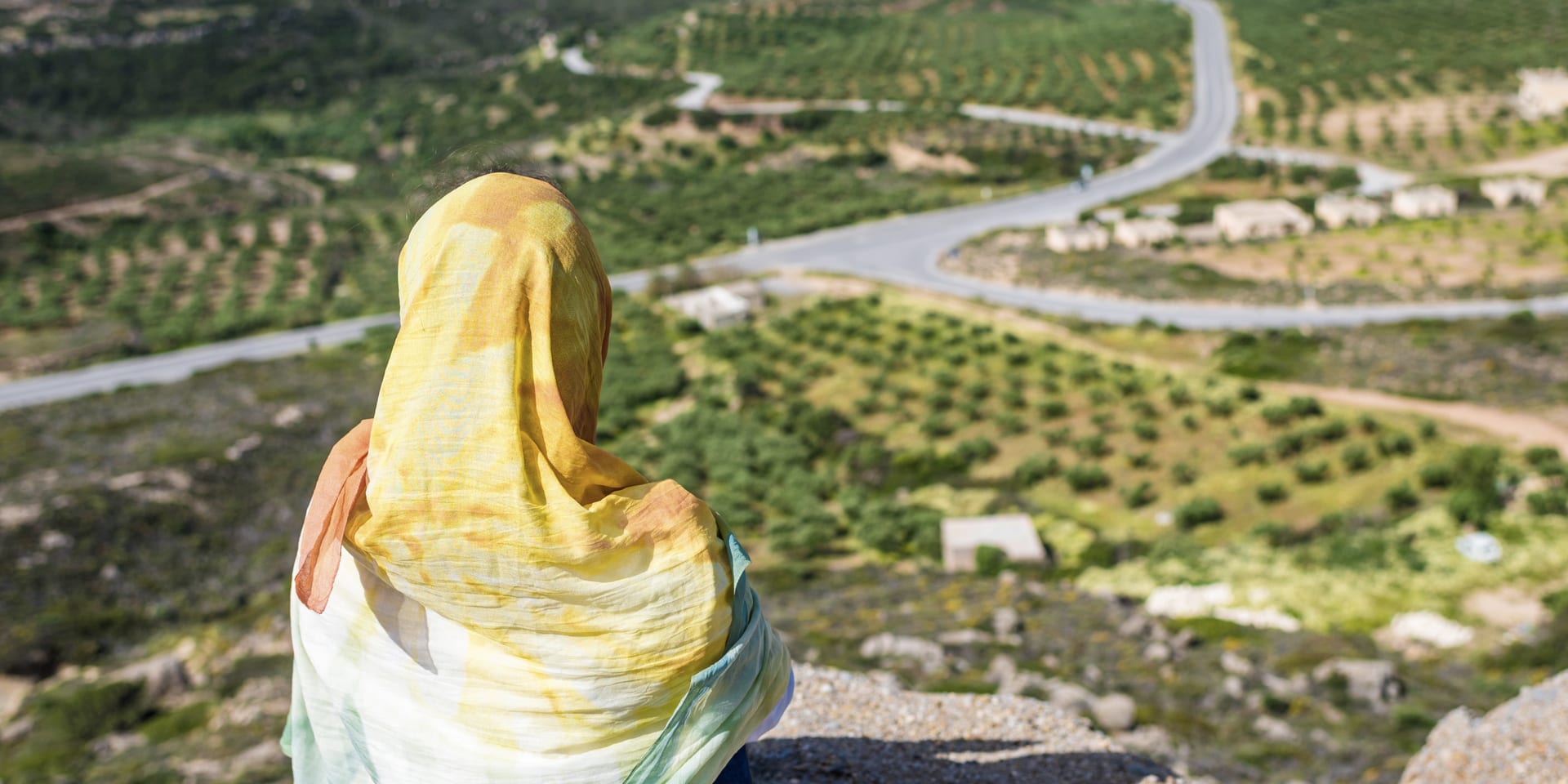 A wide river valley in Iraq with cultivated fields, seen from the hillside above.